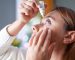Young woman putting eye drops at home
